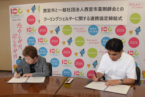 協定書に署名する石井市長と中川尚美会長